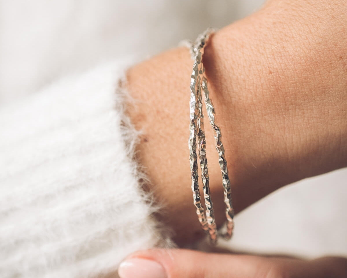 Silver bracelet on a wrist with a soft background