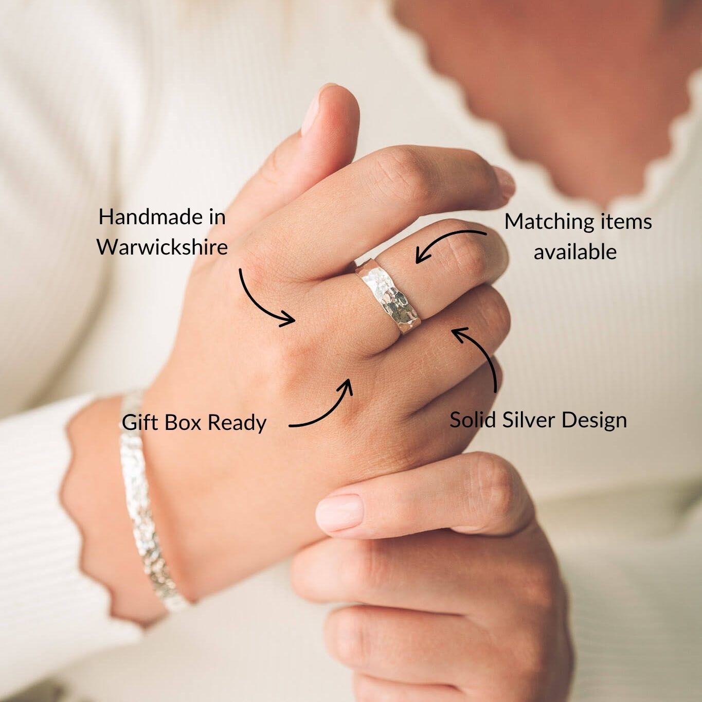 Close-up of hands wearing a silver ring with text highlighting features like 'Handmade in Warwickshire', 'Solid Silver Design', and 'Gift Box Ready'.
