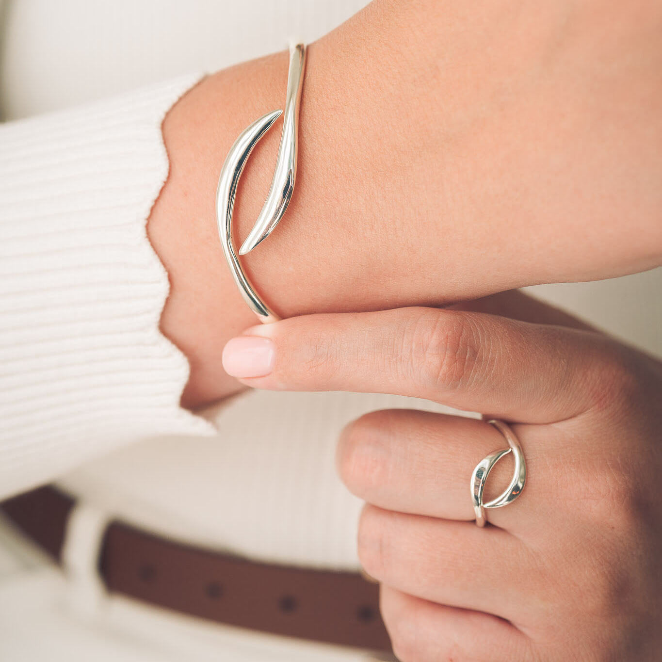 Silver bracelet and ring on a person's wrist and finger 